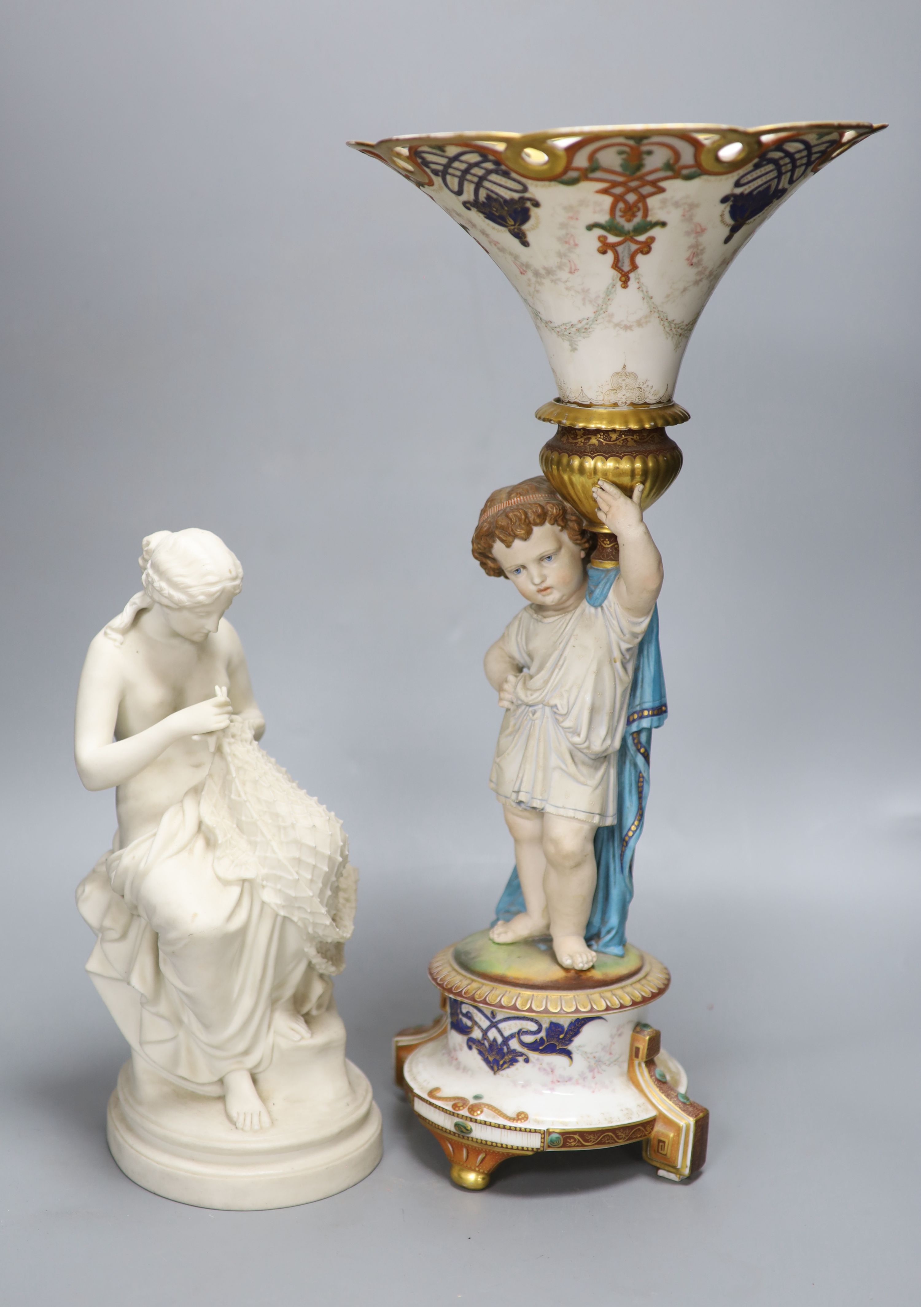 A Victorian Parian figure of a scantily clad fisher girl mending a net and a French trumpet shaped figural vase, tallest 49.5cm